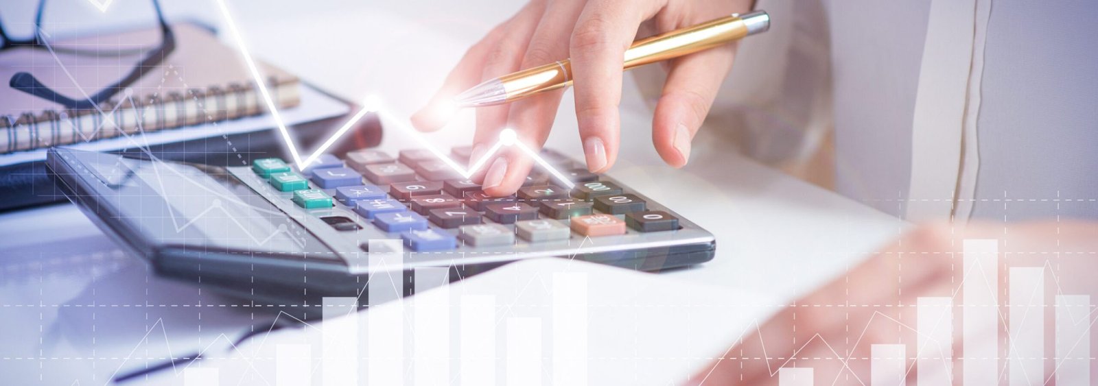 Accountant calculating profit with financial analysis graphs. Notebook, glasses and calculator lying on desk. Accountancy concept. Cropped view.