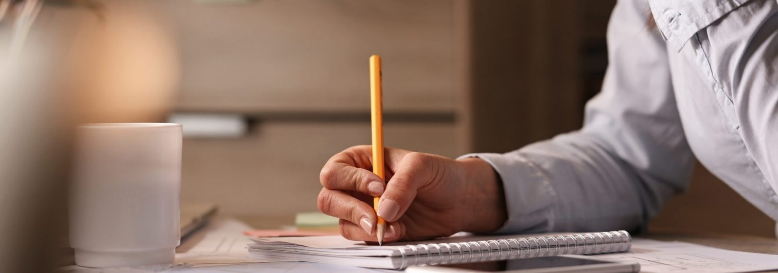 Unrecognizable businesswoman working in the office and writing business plans in her notebook.